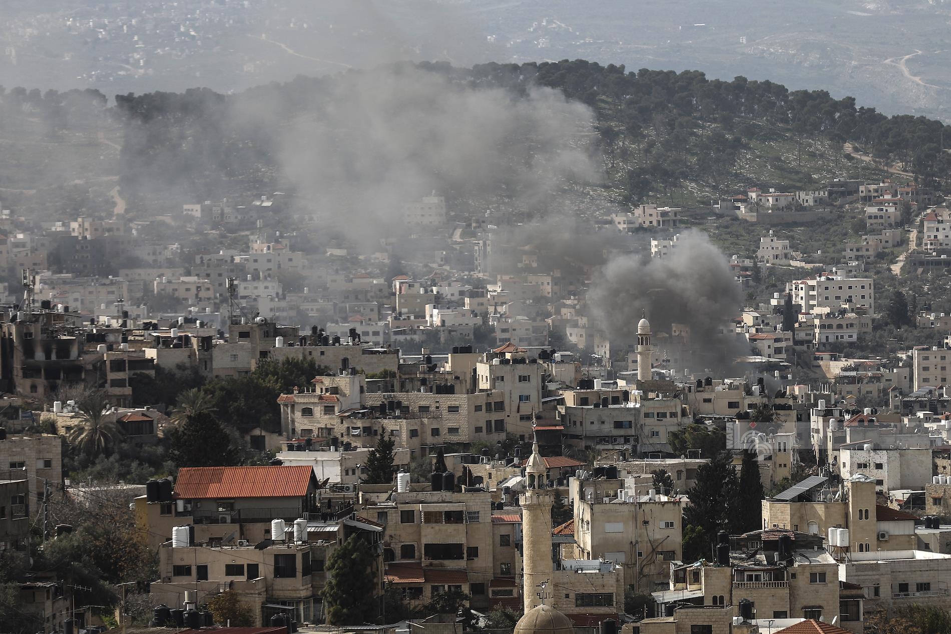 las fuerzas enemigas israelíes​ quema casas palestinas en el campamento de Jenin.